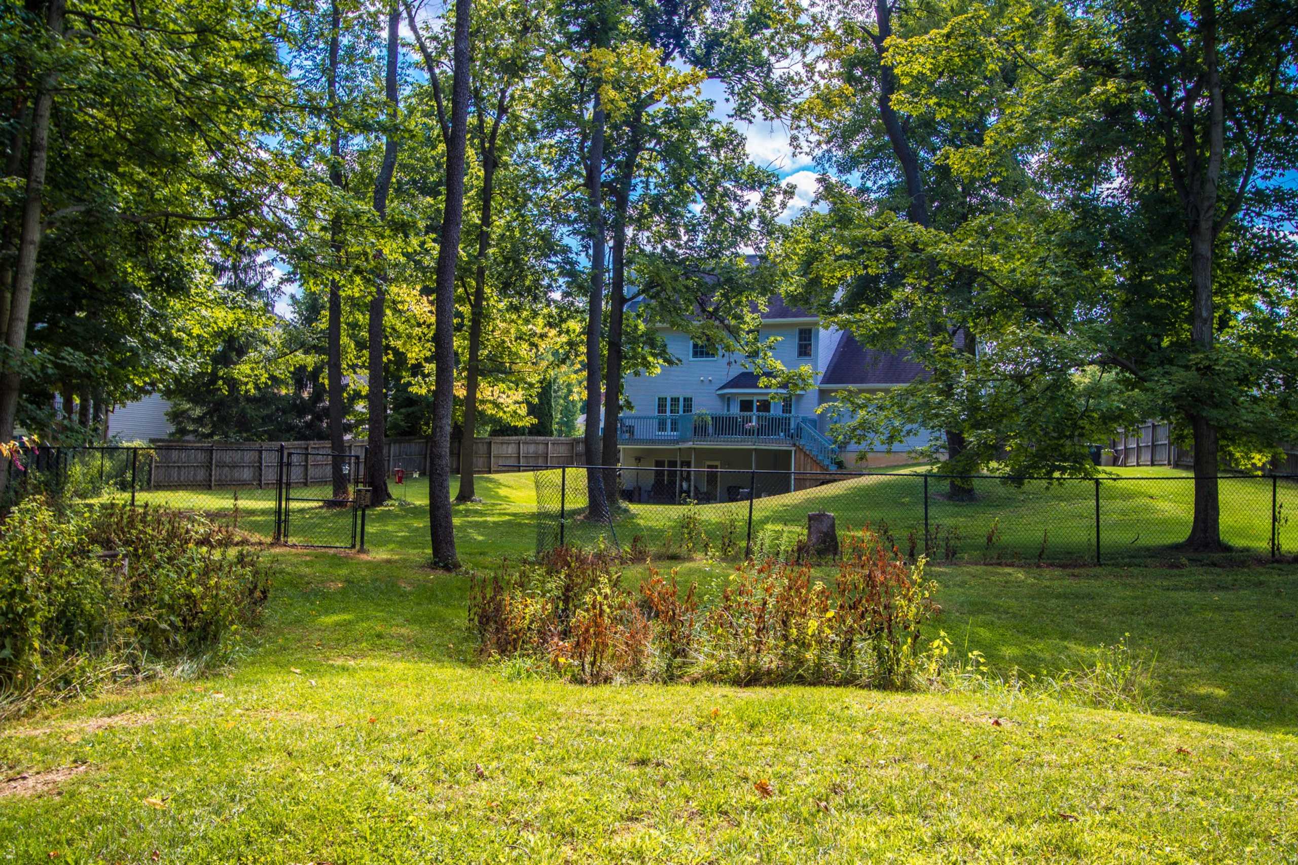Situated on nearly an acre against a wooded backdrop 
