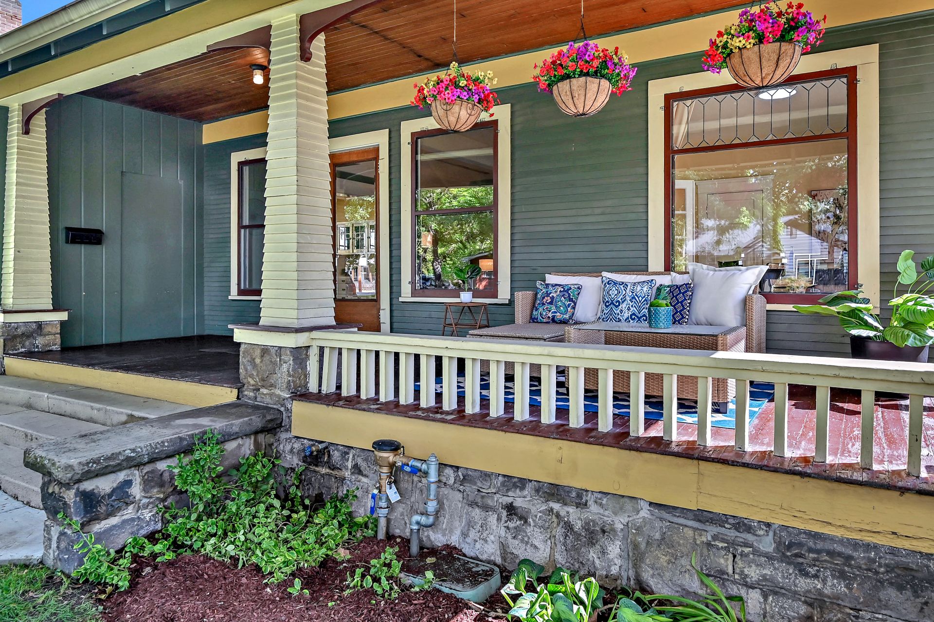 Craftsman Style Home Front Porch in North End Boise Craftsman style covered front porch with blue couch and colorful handing flower pots