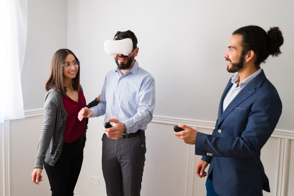 A-couple-with-a-real-estate-agent-using-VR-for-a-home-tour A couple with a real estate agent using VR for a home tour