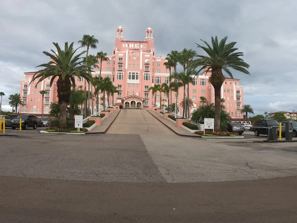 The iconic pink Don CeSar Hotel overlooking St. Pete Beach, Florida, framed by palm trees and the historic grand entrance