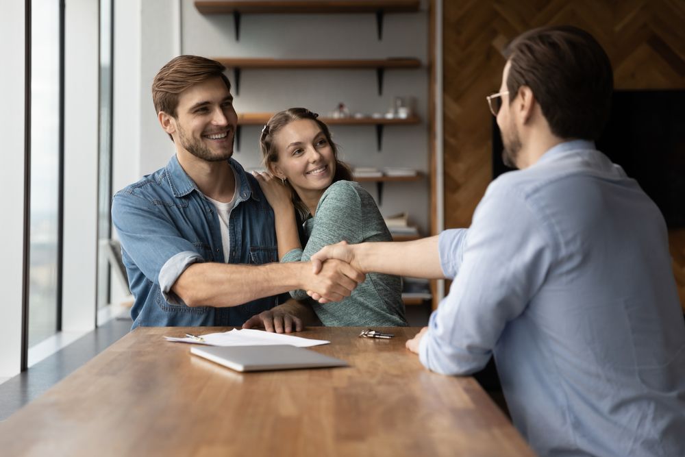 couple-handshaking-with-a-real-estate-expert couple handshaking with a real estate expert