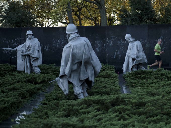 USA Today Photo gallery - A man runs past the Korean War Memorial on the National Mall on Veterans Day in Washington, DC.  Brendan Smialowski, AFP/Getty Images