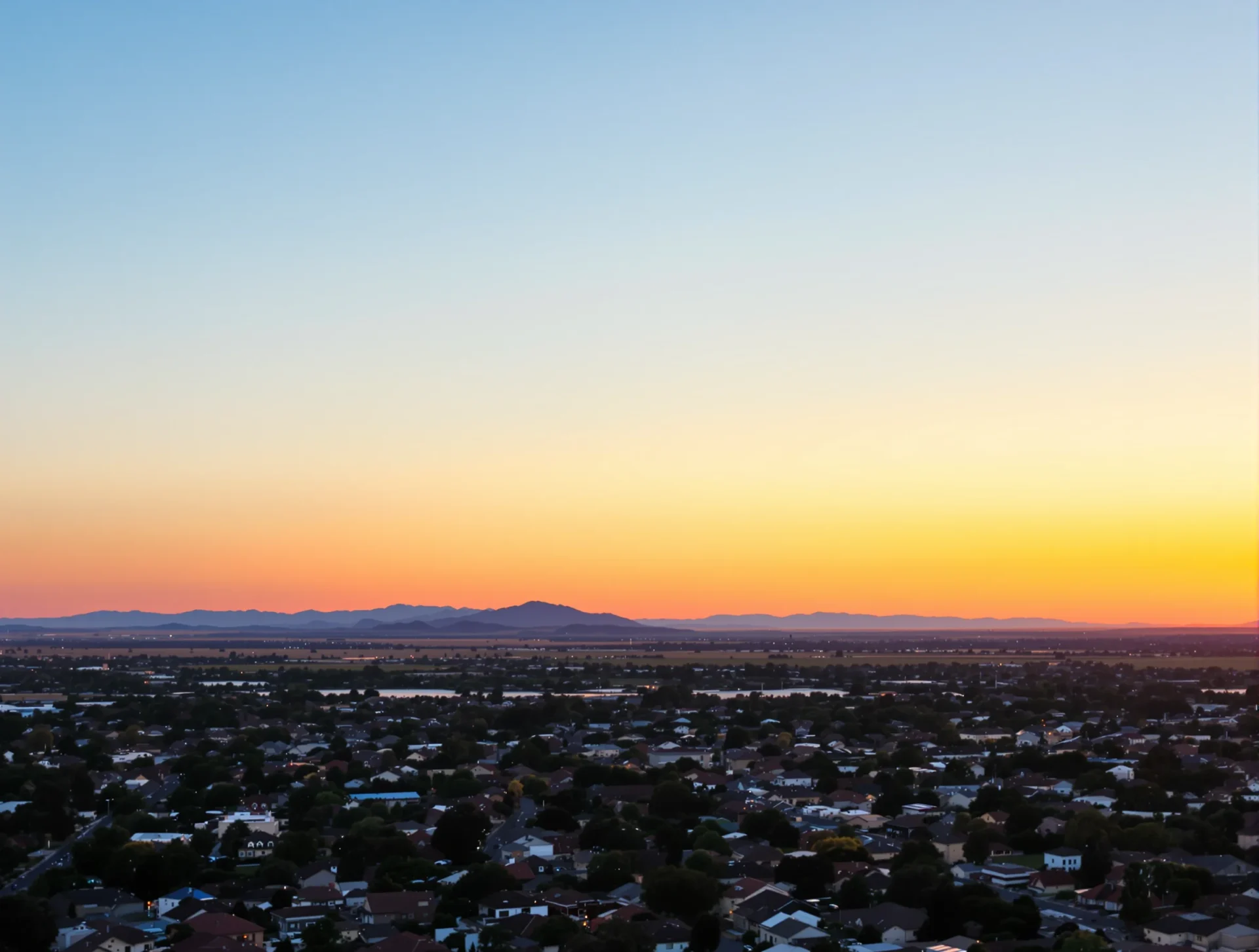 Sunset over Bakersfield neighborhoods and distant hills
