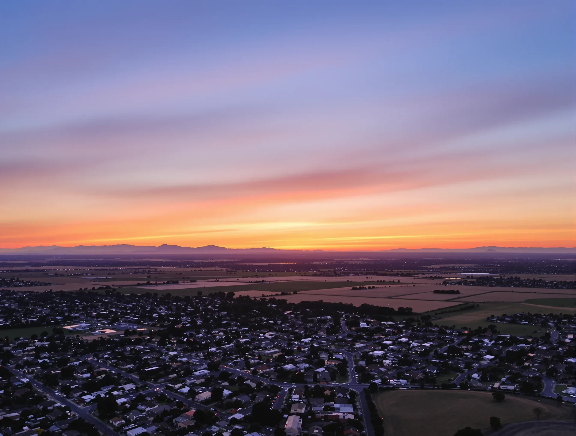 Suburban neighborhoods and open fields at sunset near Bakersfield, California