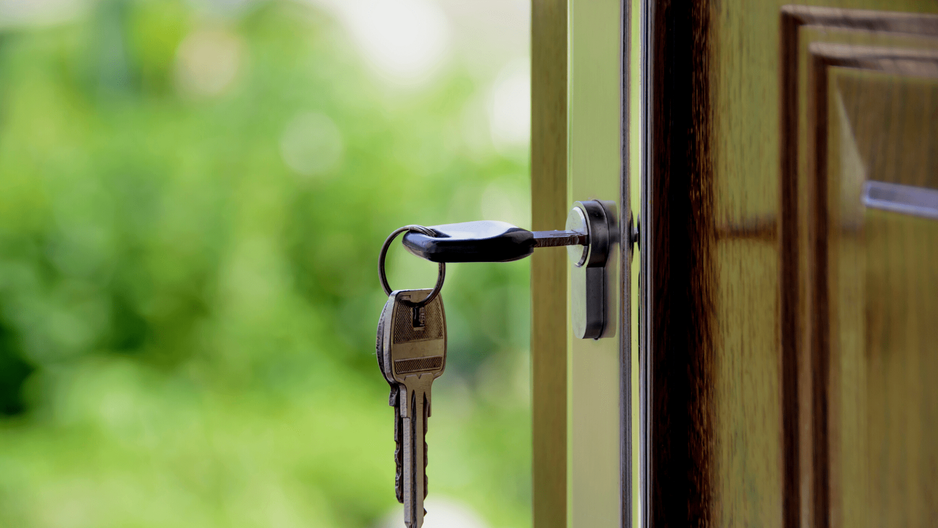 Close up of open door with key in the keyhole.