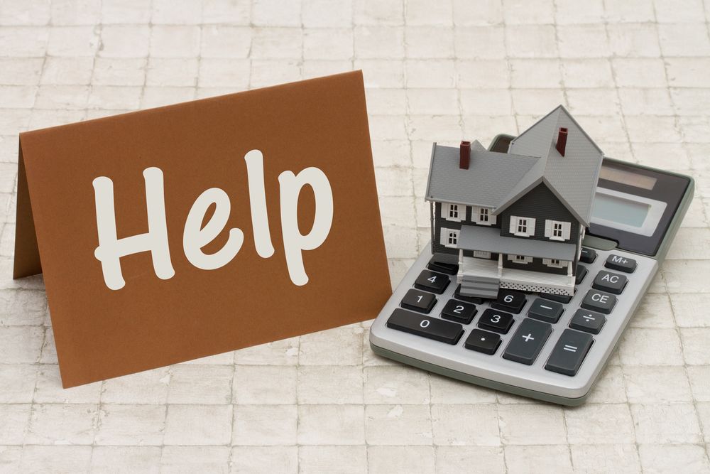 a-miniature-house-on-top-of-the-calculator-with-the-signage-help a miniature house on top of the calculator with the signage help