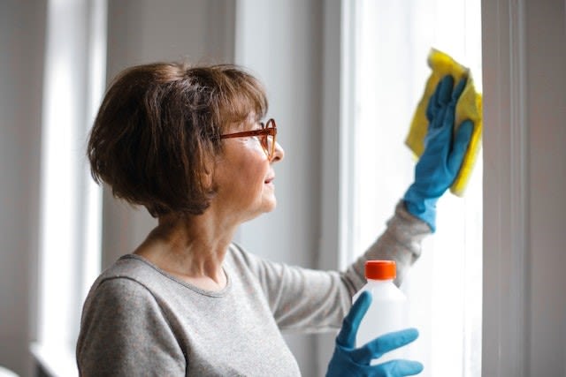 A decluttered home is much easier to clean A woman cleaning windows. If you declutter your home before selling, it will be much easier to clean and maintain it