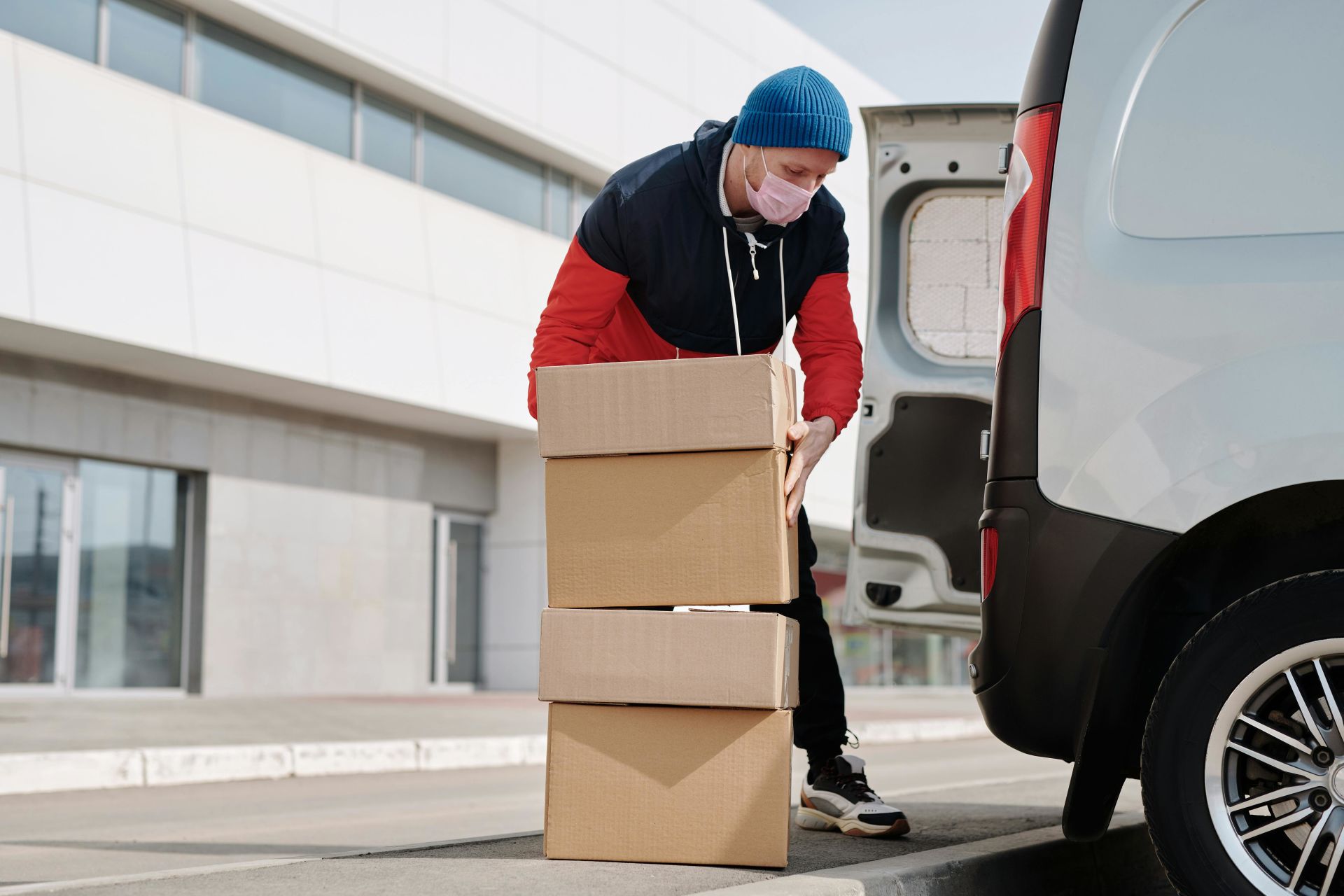 Movers are essential in ensuring a simple and efficient packing and moving. A man wearing a face mask and carrying boxes.