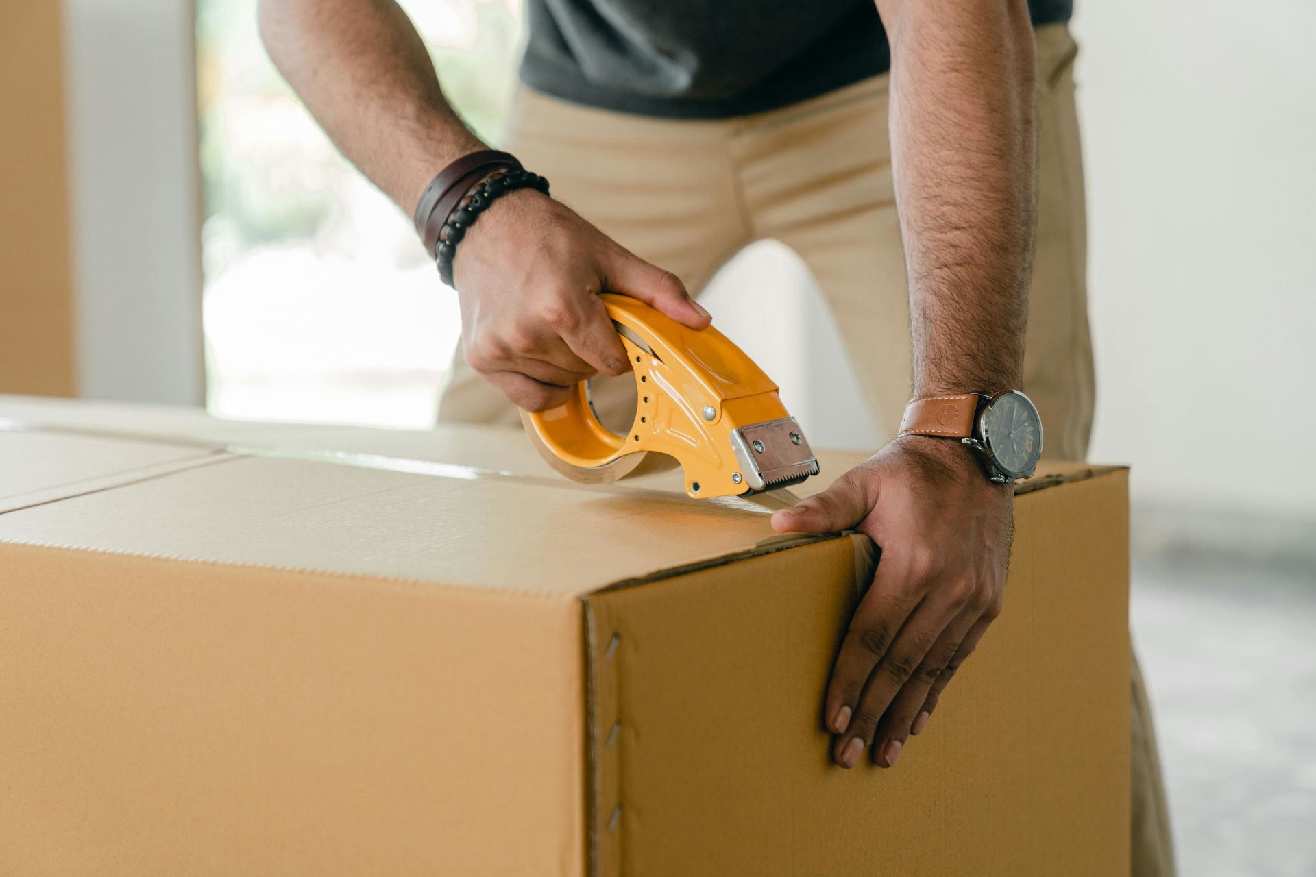 Pack your items carefully when moving to avoid expensive damage A man packing a box while following Connecticut's storage regulations.