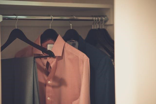 Close-up of shirts on hangers in a closet.