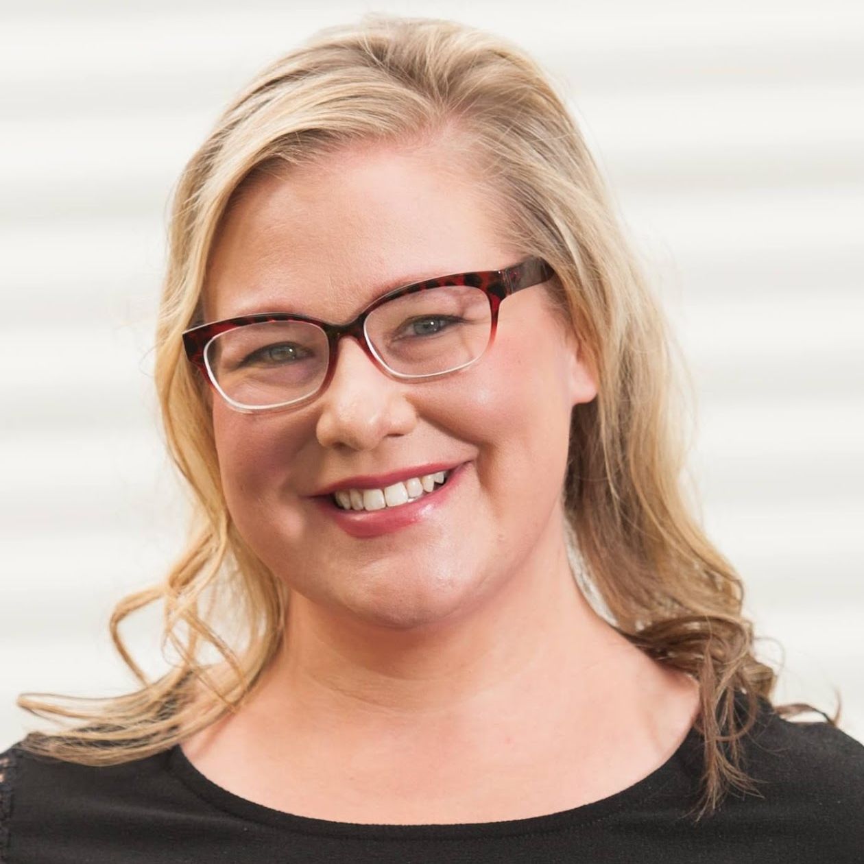 Photo of Sara smiling in a black shirt.