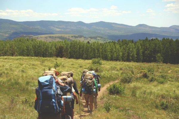 Hikers at the base of a mountain range