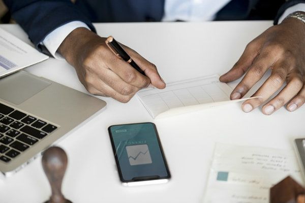 Someone looking at finances using his phone and computer