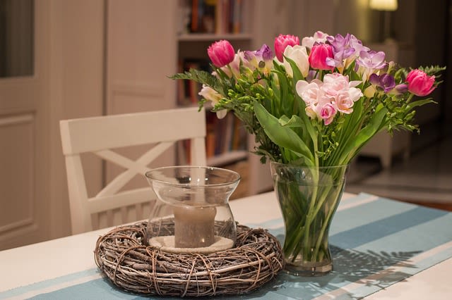 Kitchen Table topped with a candle and a beautiful bouquet of flowers