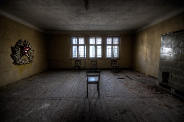Dark empty indoor room with fireplace and chair