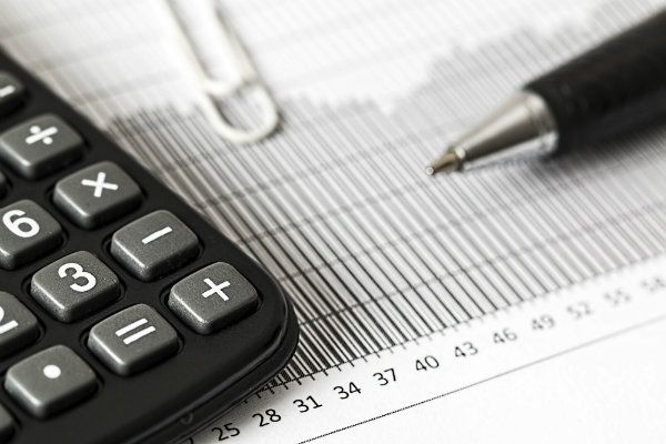A calculator and a pen laying on top of some data forms