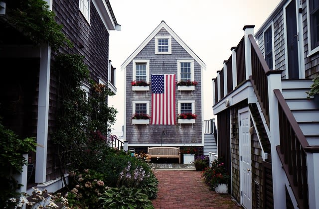 a House by the ocean in a cute neighborhood with an american flag in front