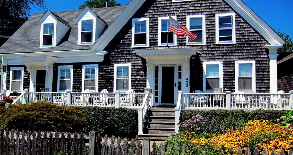 A Cape-style home with an American Flag in front