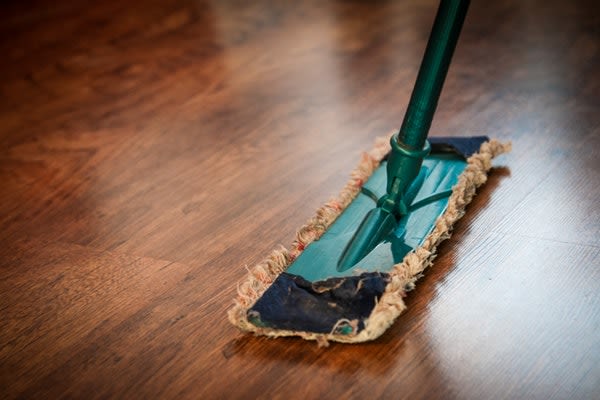 Hardwood floors being swept and cleaned with a dust mop