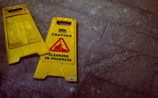 Yellow Caution sign laid out on floor for cleaning prep