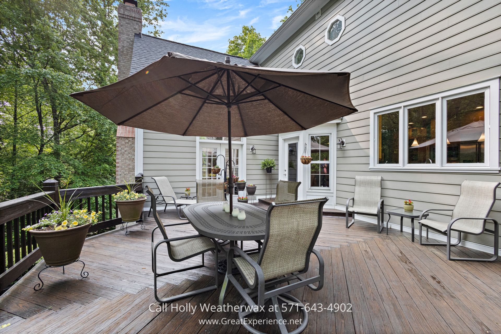 Reston VA Real Estate for Sale - Tranquil outdoor deck in lush surroundings, perfect for relaxation and gatherings. Relaxing outdoor deck with a stylish table, chairs, and umbrella