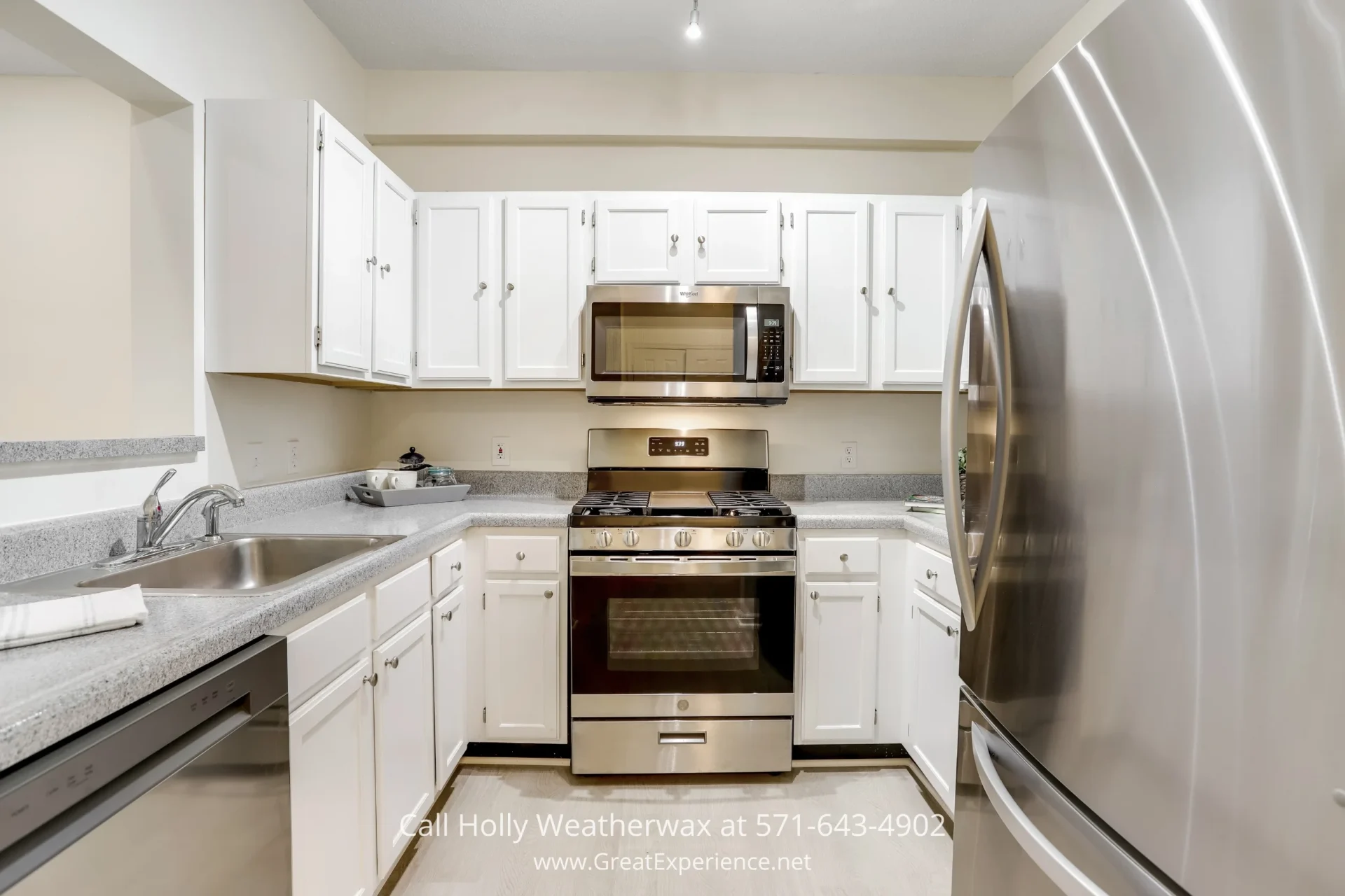 Reston VA Home - The updated kitchen of this condo in Reston VA features brand-new stainless steel appliances. A sleek stainless steel stove, cabinets, and microwave in a kitchen