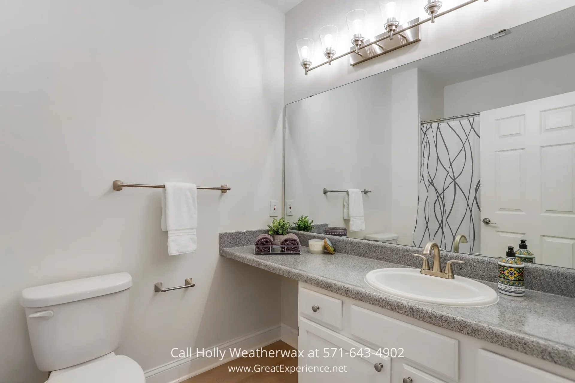 Reston VA Homes - The luxurious bathroom of a stunning Reston VA condo that features updated fixtures and lots of counter space A tidy white room with a shelf and a sink