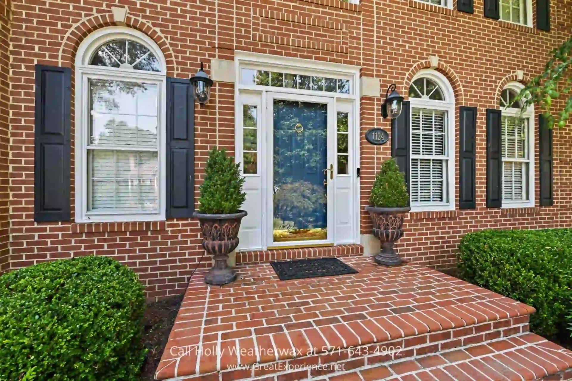 North Reston Home For Sale - A luxurious home in North Reston VA on more than ½ acre. a brick house with two planters on the front steps