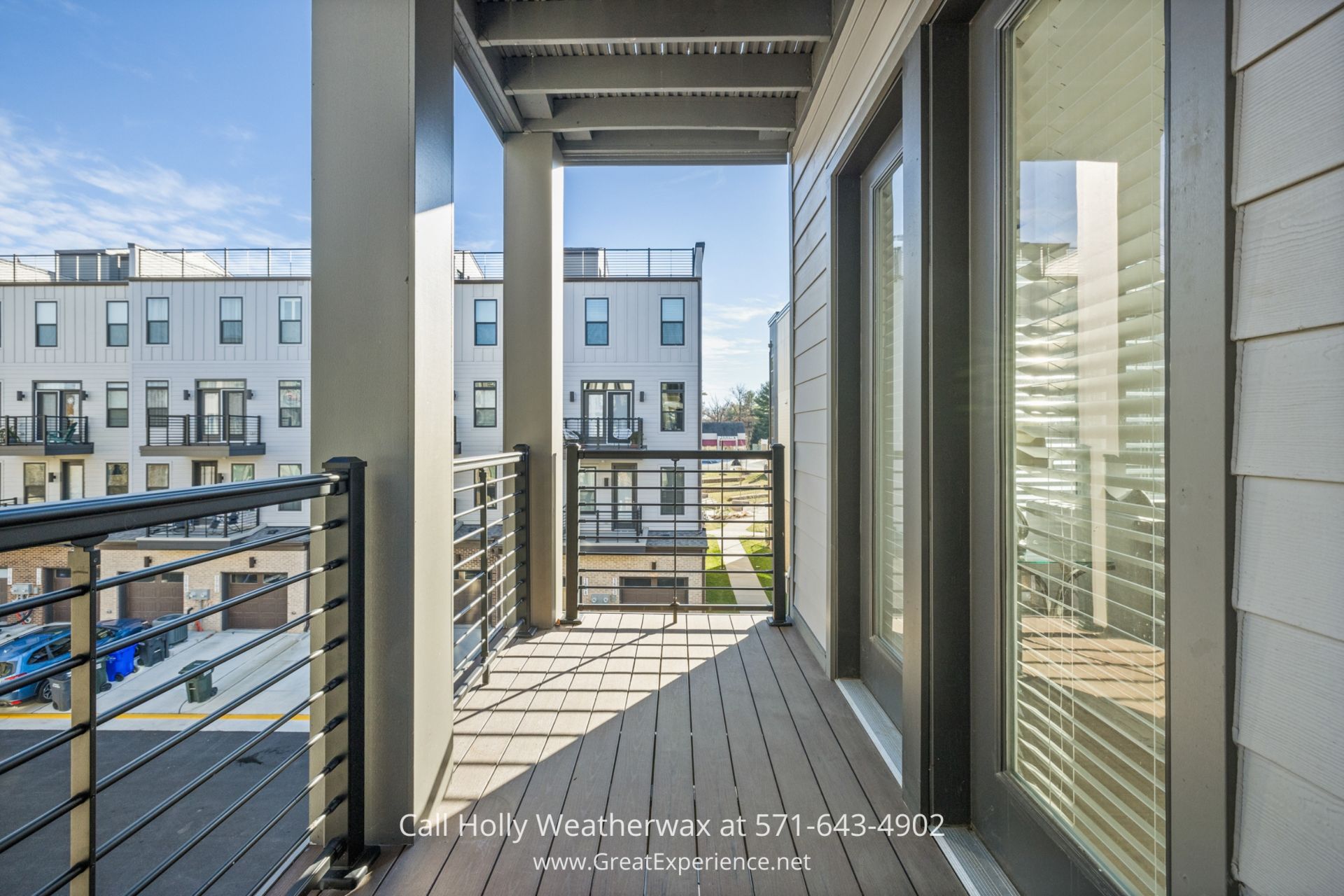 Condo for Sale in Reston VA - Expansive balcony of a North Reston VA home offers stunning views ideal for relaxation a balcony with a wooden floor and railing