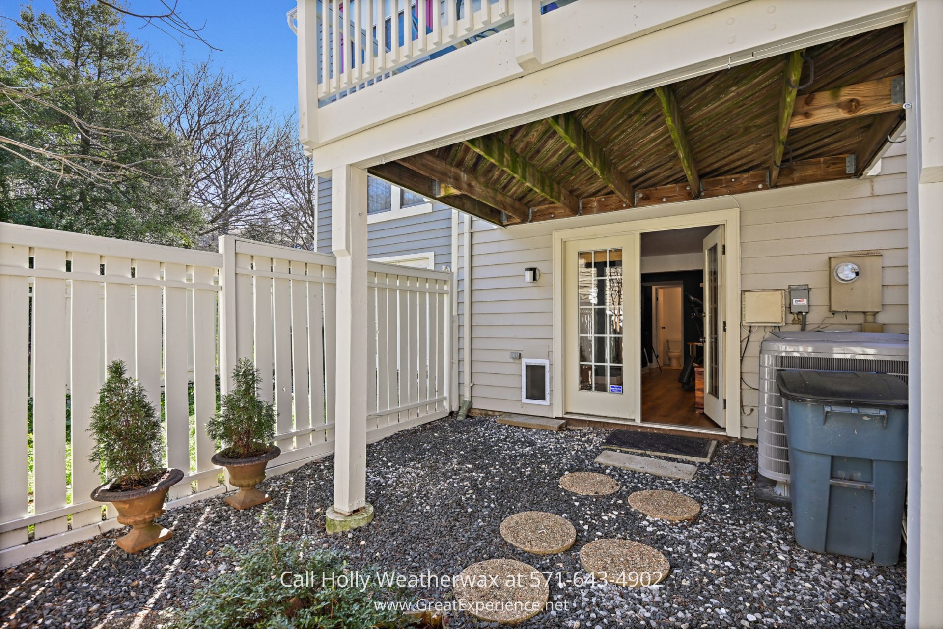 Reston VA Home - Inviting deck accessible from the kitchen of the Reston townhouse, ideal for morning coffees or evening entertainment, overlooks the tranquil backyard. a patio with a grill and a white fence
