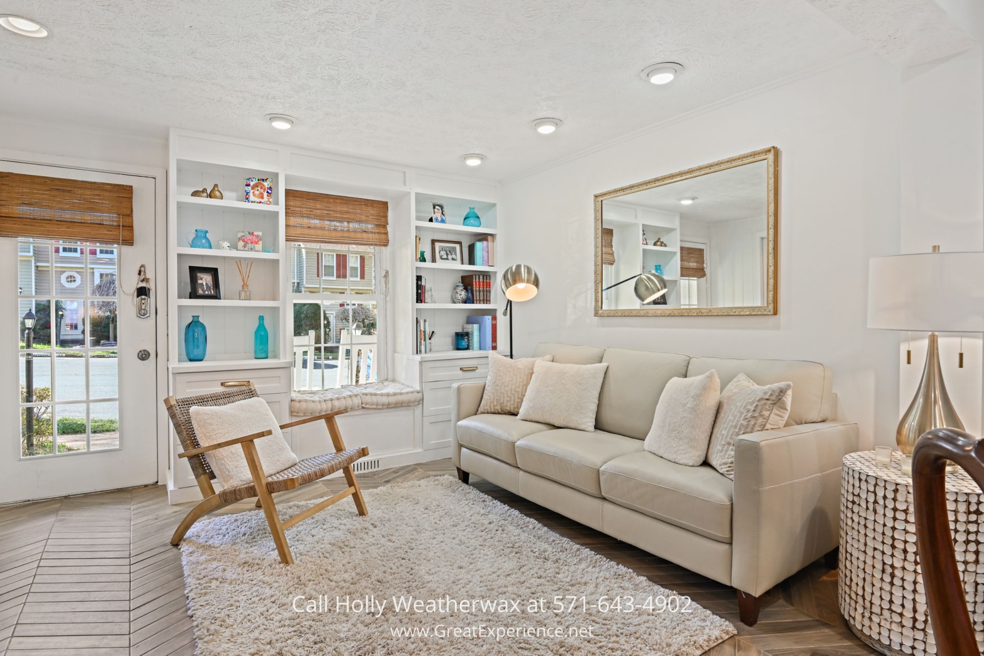 Reston VA Home for Sale - Bright and welcoming living room of a Reston townhome features elegant herringbone floor tile, built-in bookshelves, and a cozy window seat, perfect for relaxing with a book. a living room filled with furniture and a large mirror