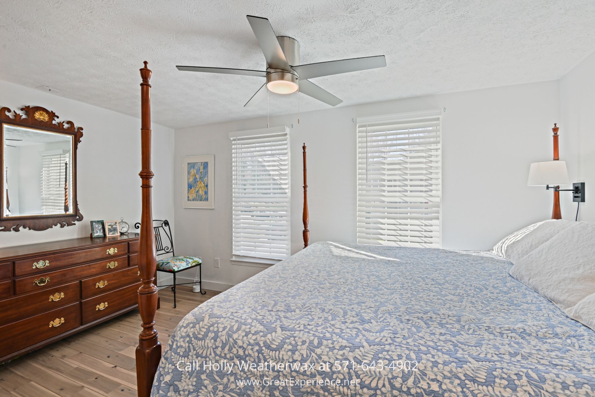 Reston VA Townhome for Sale - Primary bedroom in elegantly designed Reston townhome. Serene retreat with exclusive bathroom, sleek modern decor, and direct deck access. a bedroom with a bed, dresser, mirror and ceiling fan