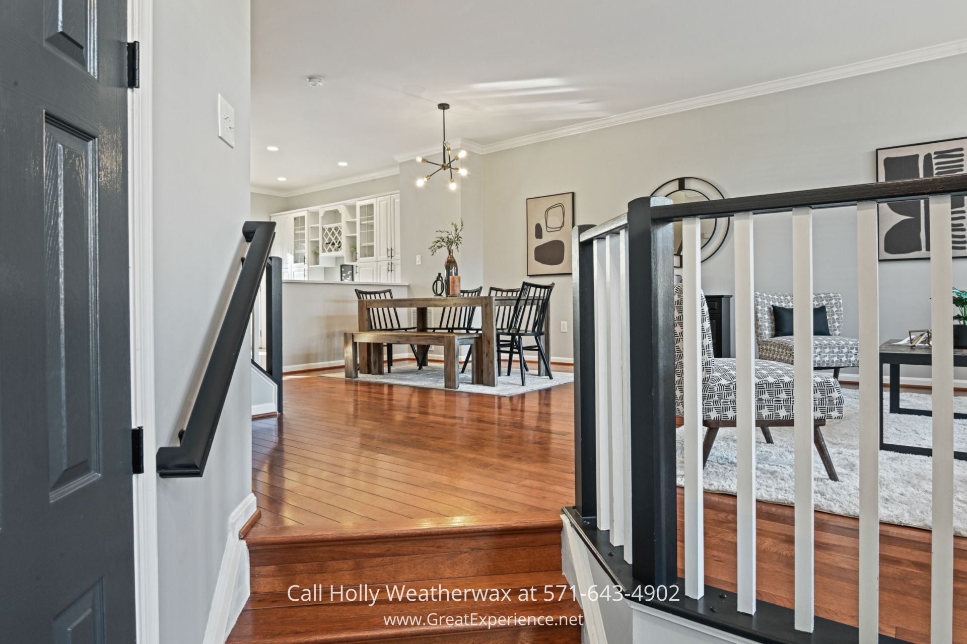 Welcoming Foyer Entrance in Reston VA Townhouse A bright entryway with warm hardwood flooring leading up to an open dining and living area, featuring a sleek black staircase railing.