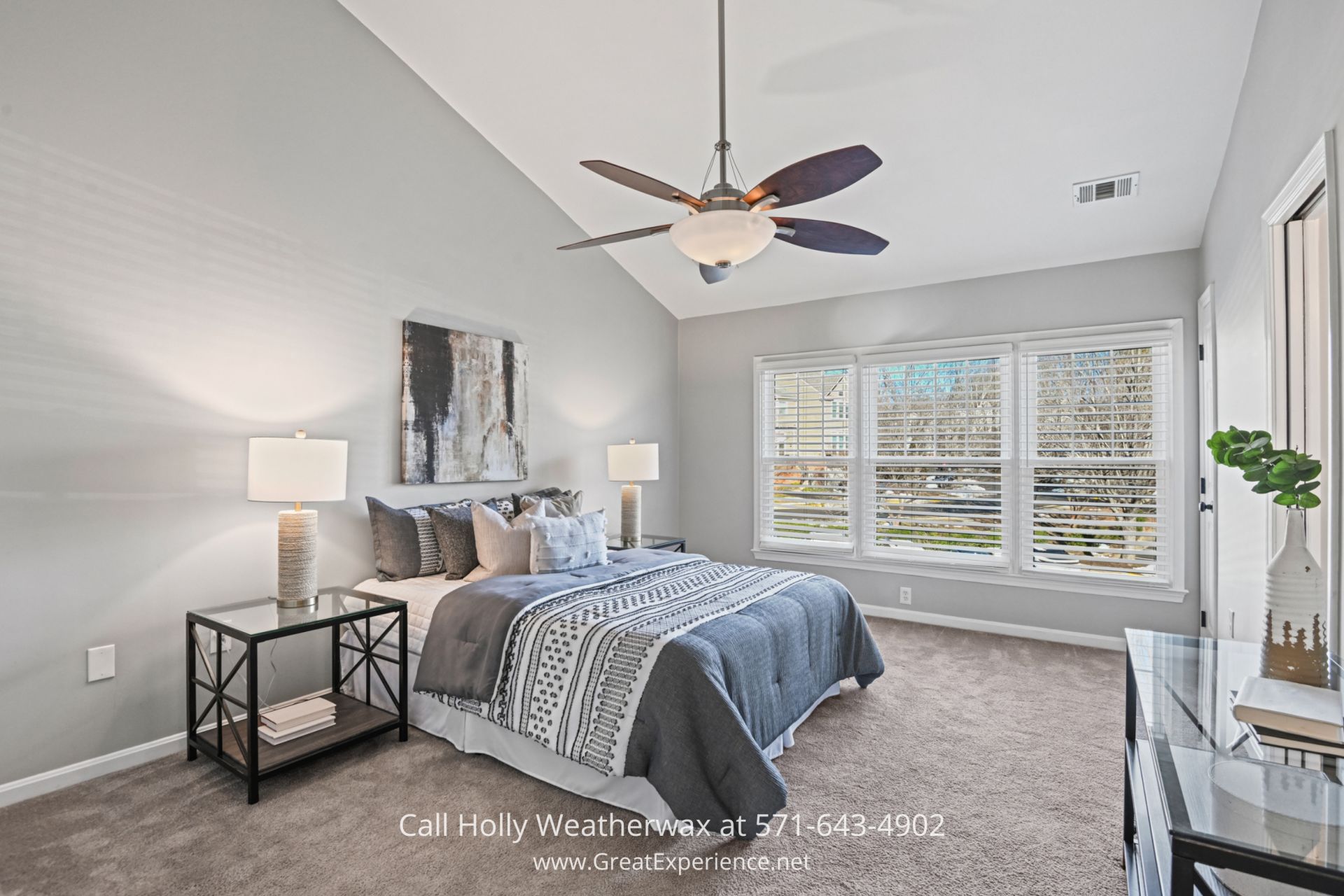 Luxurious Primary Suite in Reston VA Townhouse A spacious bedroom with a vaulted ceiling, a king-sized bed with stylish bedding, large windows with white blinds, and neutral decor creating a calming atmosphere.
