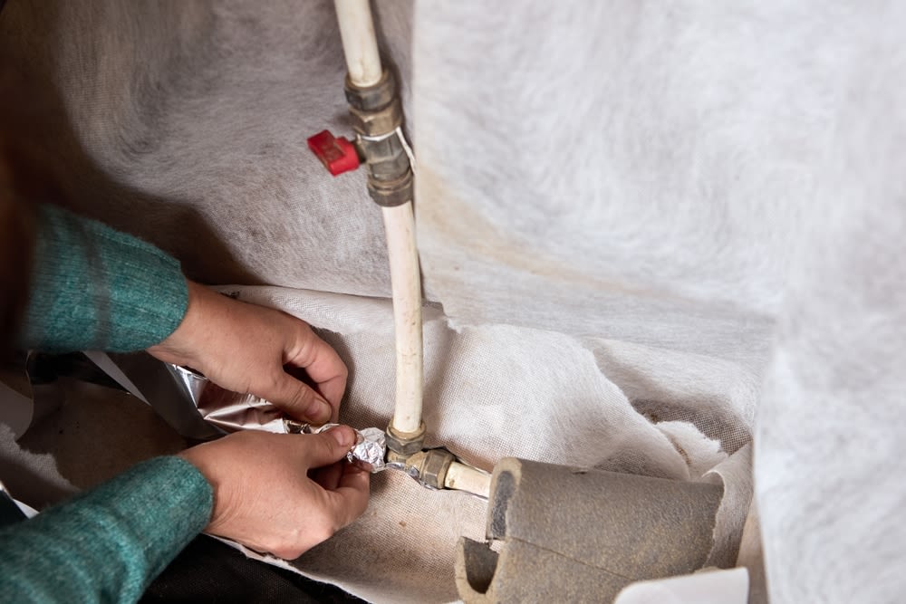A-Person-Installing-Pipe-Insulation A Person Installing Pipe Insulation