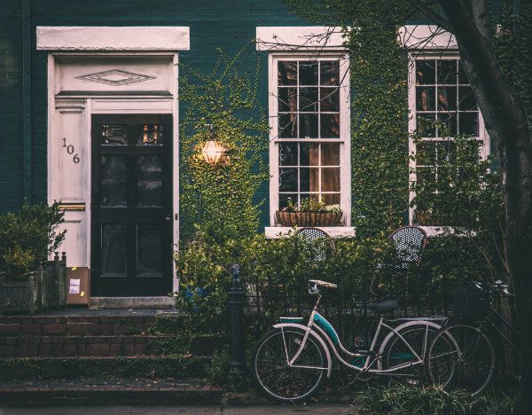 Historic Brownstone townhouse covered in ivy with bike to the side 