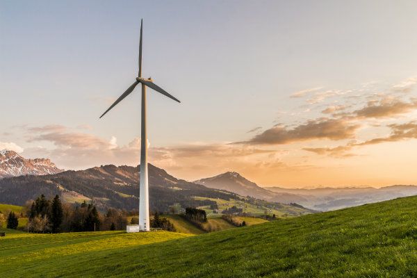 A Windmill on top of a hill by a town