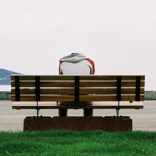 Someone sitting on a bench and stressed out about the home buying process