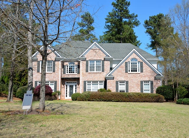 A big house with an open house sign in front of it