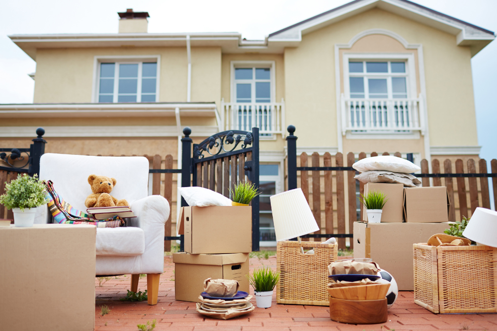 moving-boxes-and-furniture-outside-a-suburban-home moving boxes and furniture outside a suburban home