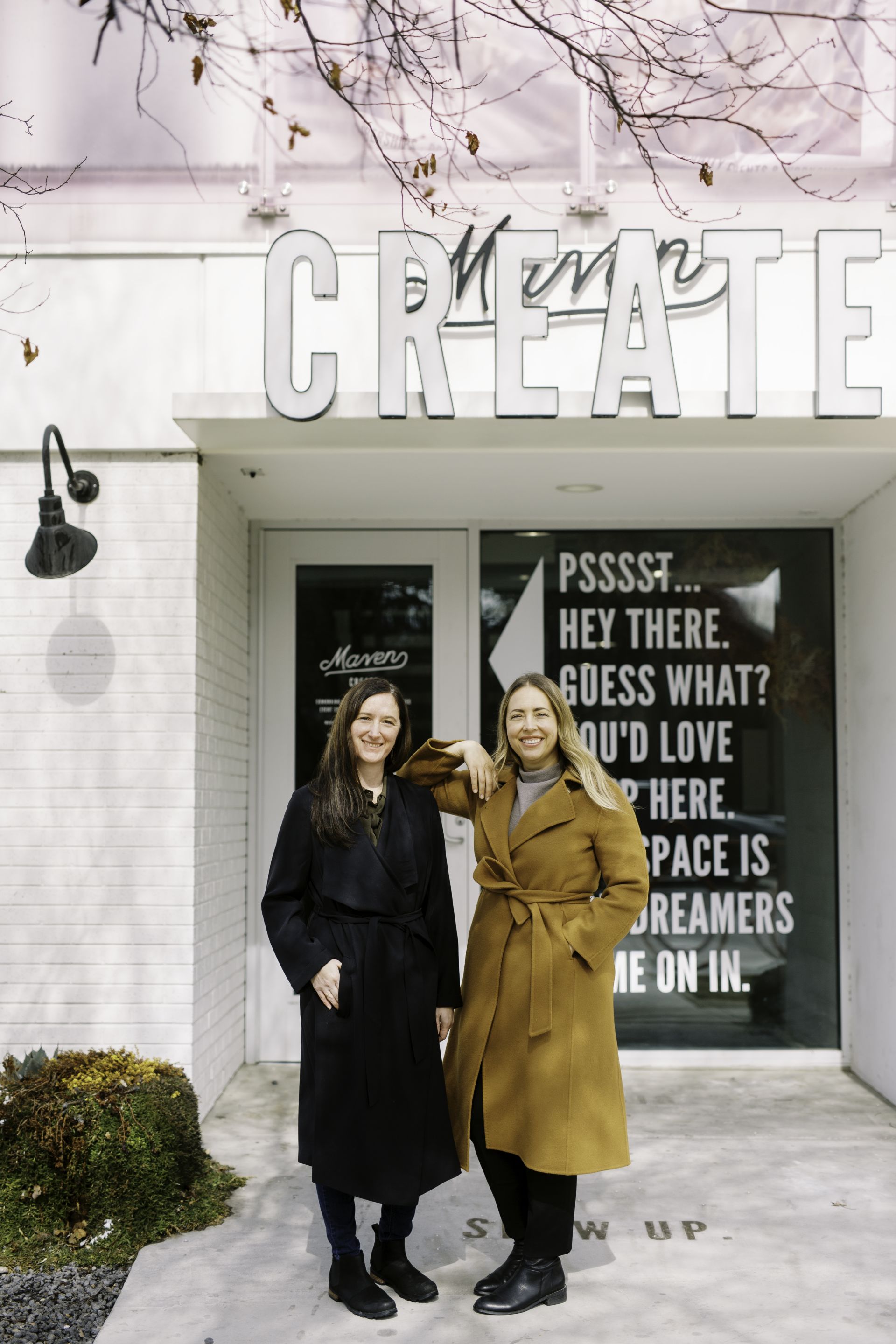 two female real estate agents stand outside their brokerage office