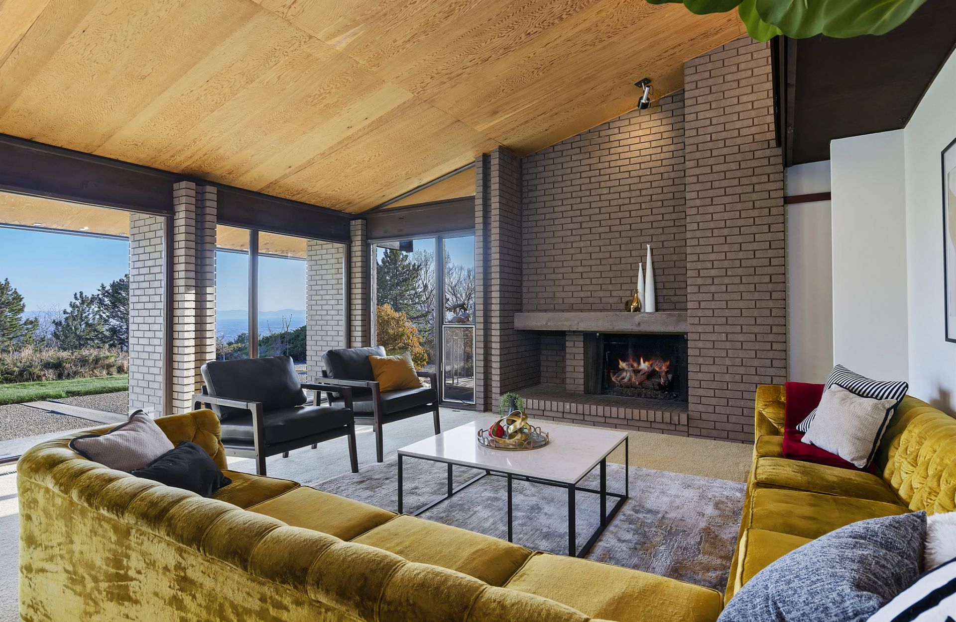 A spacious modern home with large windows and gold couch