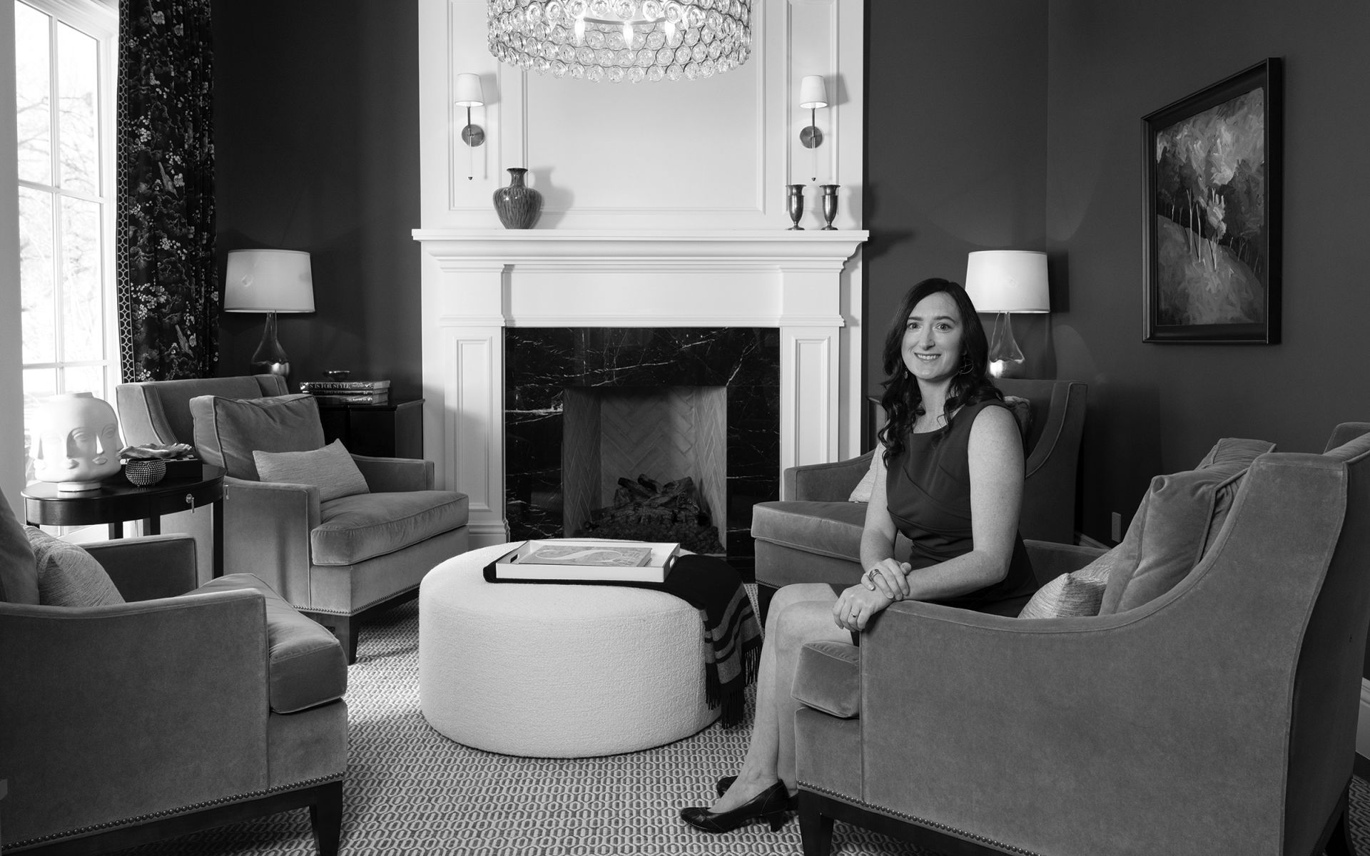 real estate investing for women a woman with dark chair sits in an armchair in a modern living room