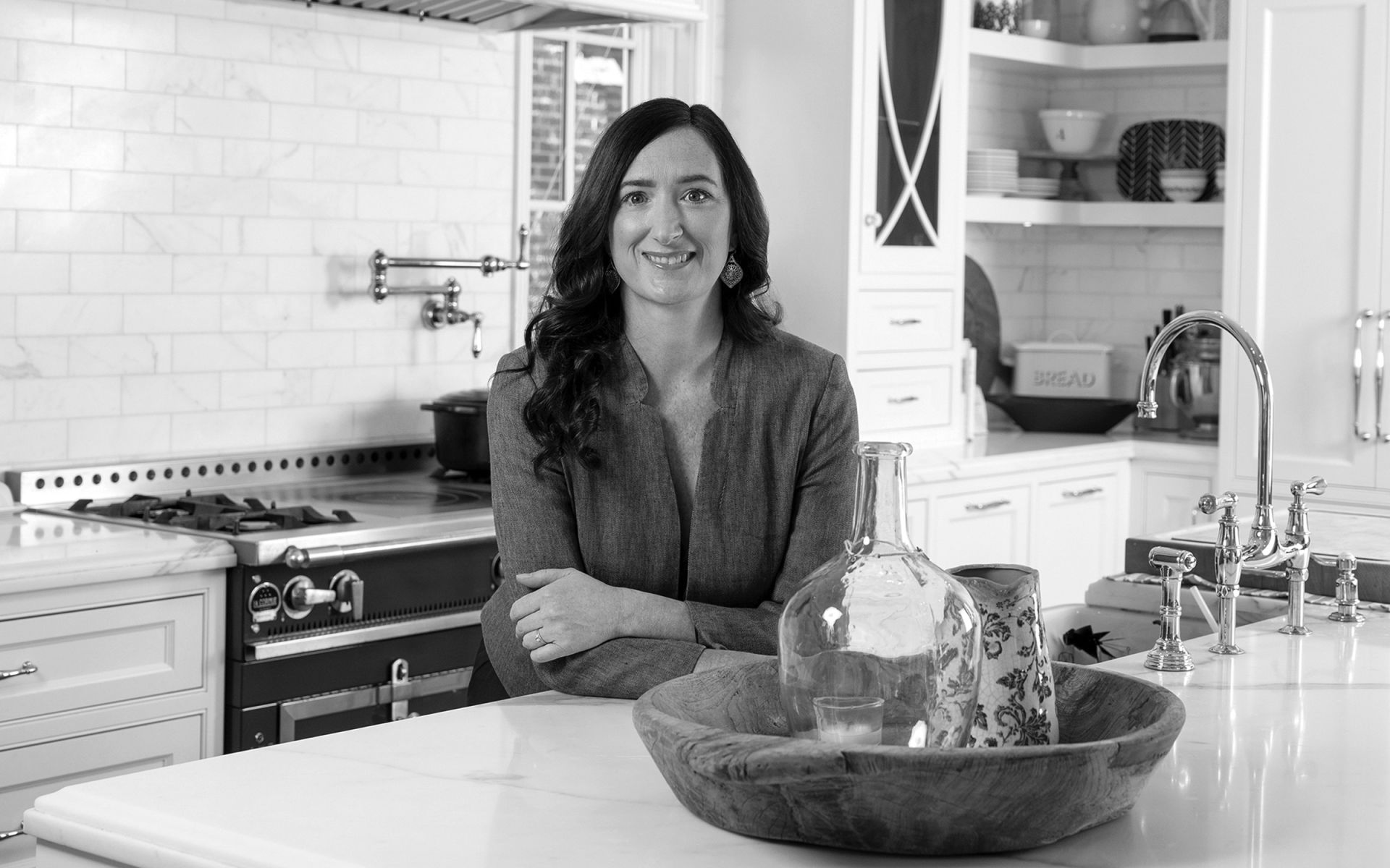 monique higginson of market source real estate a woman with dark hair leaning against a counter in a modern kitchen