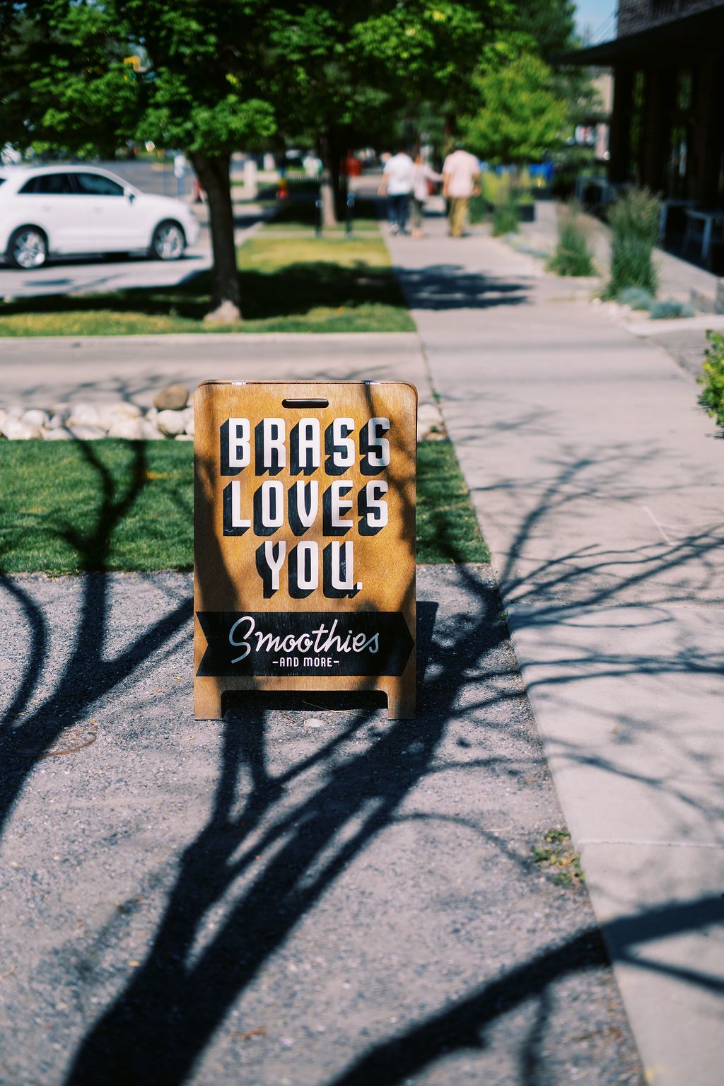 Best Suburbs of Salt Lake City a wooden a frame sign reads Brass Loves You: Smoothies and More