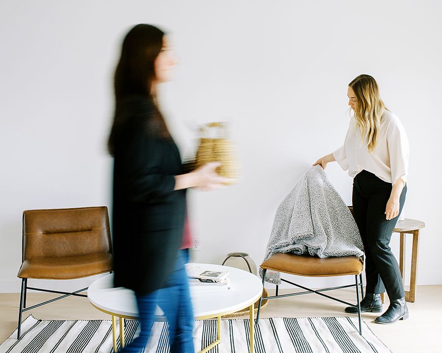selling a home in utah two women set up furniture to sell a home