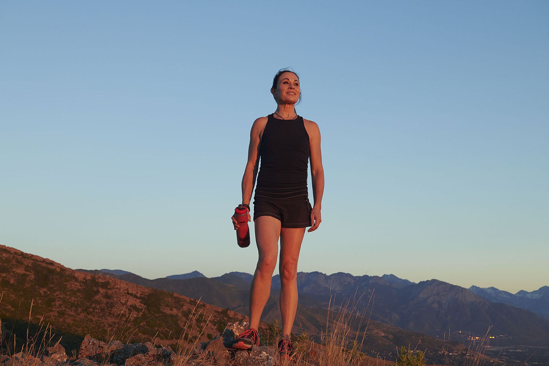 how to rent out your home a beautiful woman with dark hair stands on a mountain at golden hour
