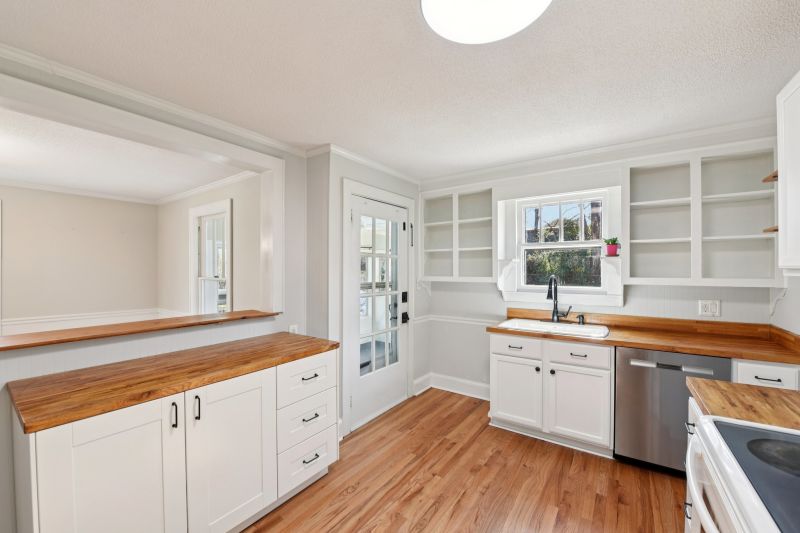Updated kitchen with butcher block counters and modern fixtures in renovated bungalow near downtown Concord NC.