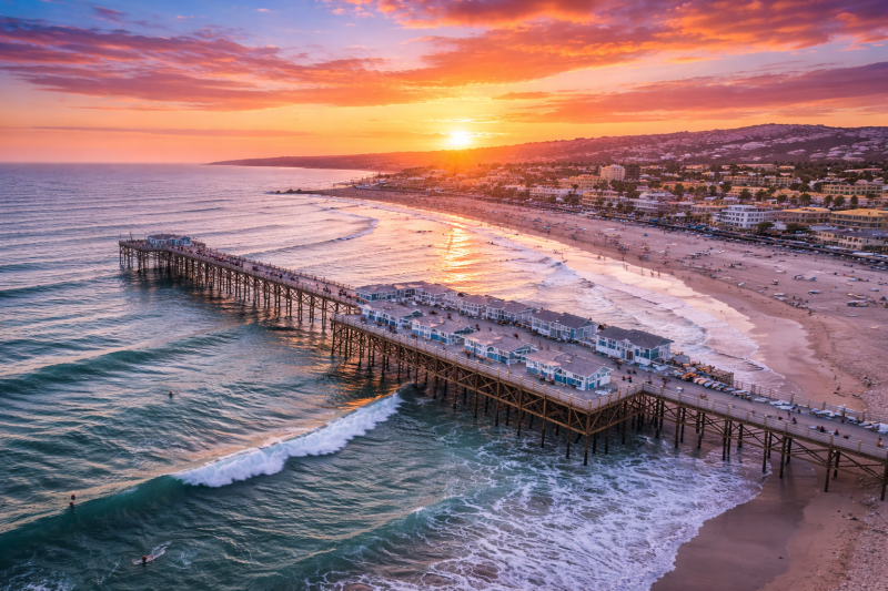 Aerial view of Crystal Pier in Pacific Beach San Diego at sunset with ocean waves and beachfront cottages