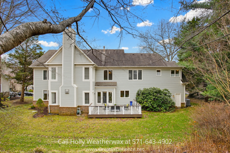 Rear exterior of 11316 Bright Pond Lane, Reston, VA featuring a spacious backyard, private deck, and mature trees offering a peaceful setting.